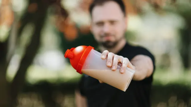 A dog owner reading the label on a bottle of canine supplements